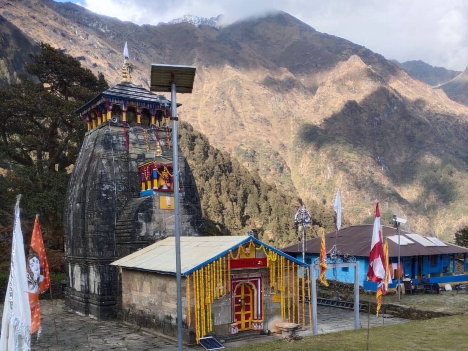 Madhyamaheshwar Temple nestled in the serene Garhwal Himalayas, surrounded by lush meadows and snow-capped peaks.