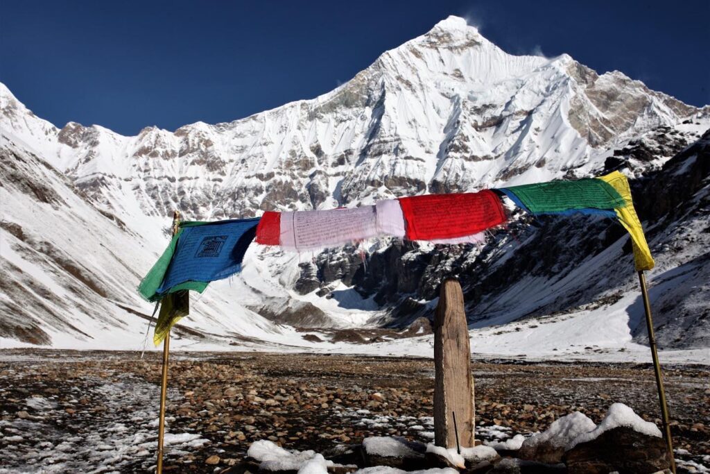 Tibetan lungta flags flutter in front of Nanda Devi East Base Camp, one of India’s most difficult and spiritually revered treks.