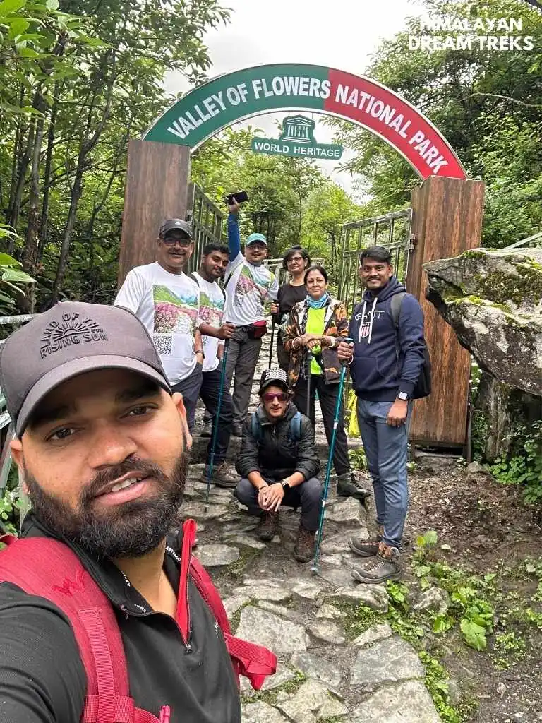 Tourists and guide posing for a selfie at the entrance of Valley of Flowers National Park just before the journey begins to VOF