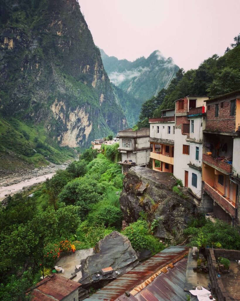 Govind Ghat with riverside buildings and mountain backdrop.