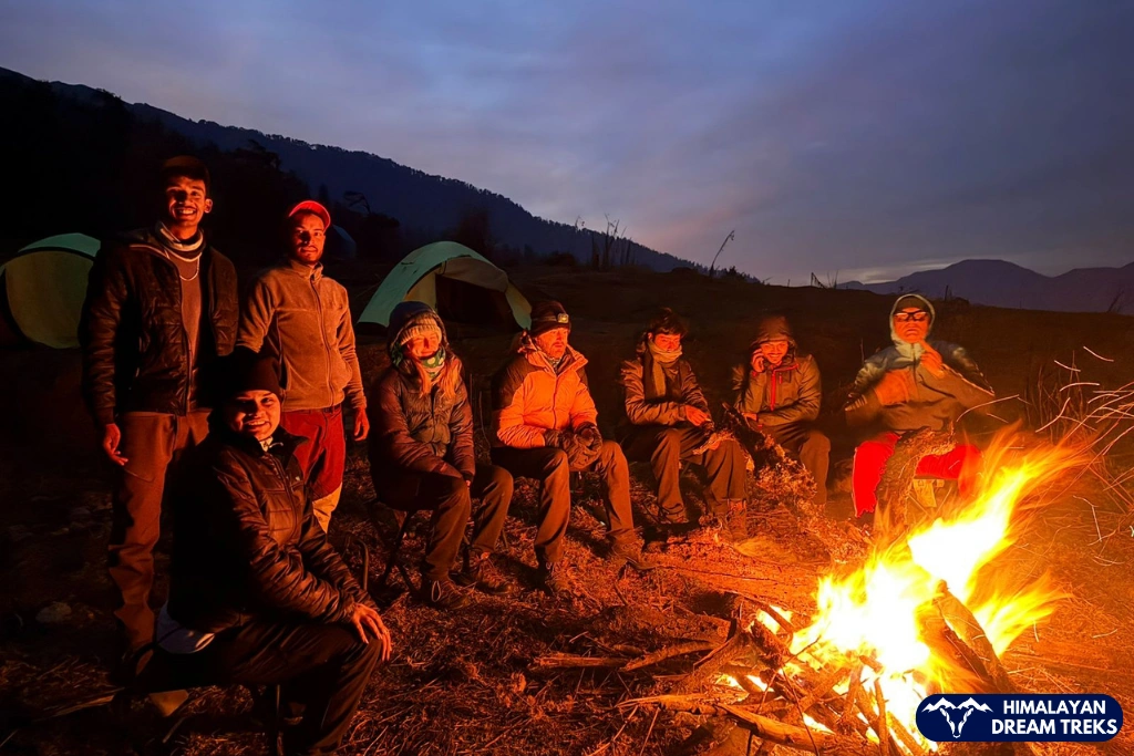 Trekkers enjoying a warm bonfire at the campsite at night