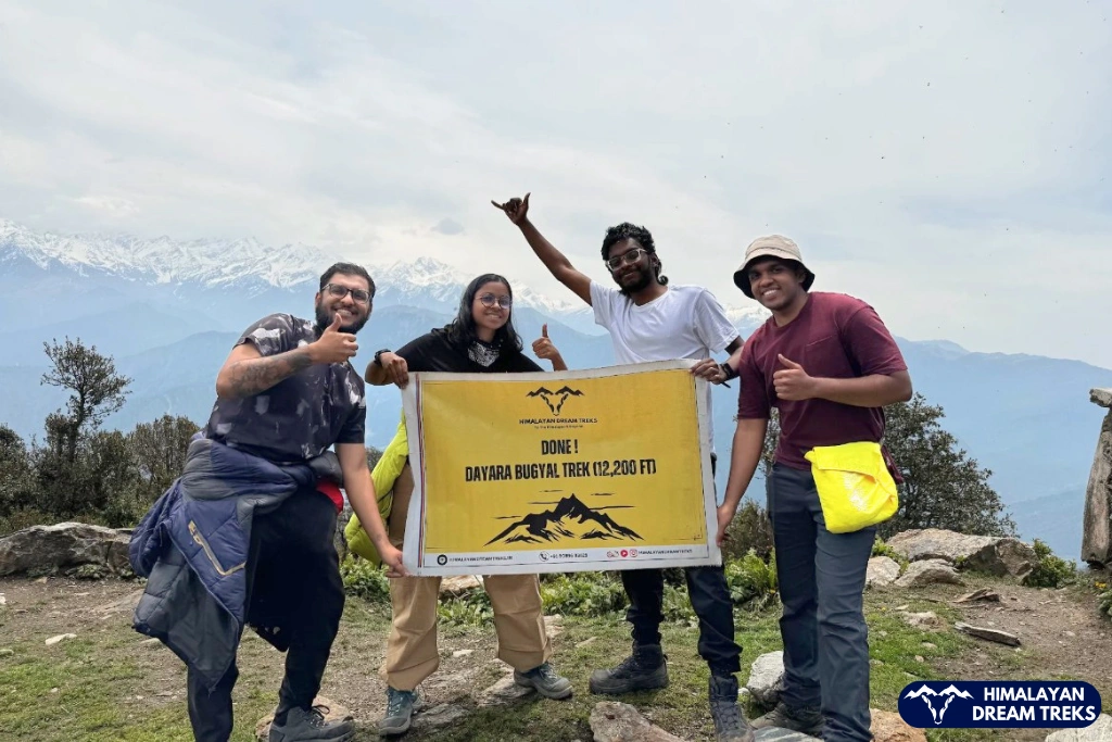 Group of trekkers celebrating after reaching the Dayara Bugyal summit