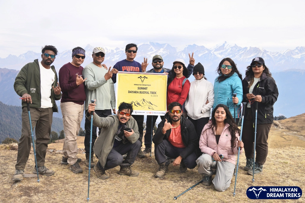 Trekkers posing together at Dayara Bugyal summit in Uttarakhand