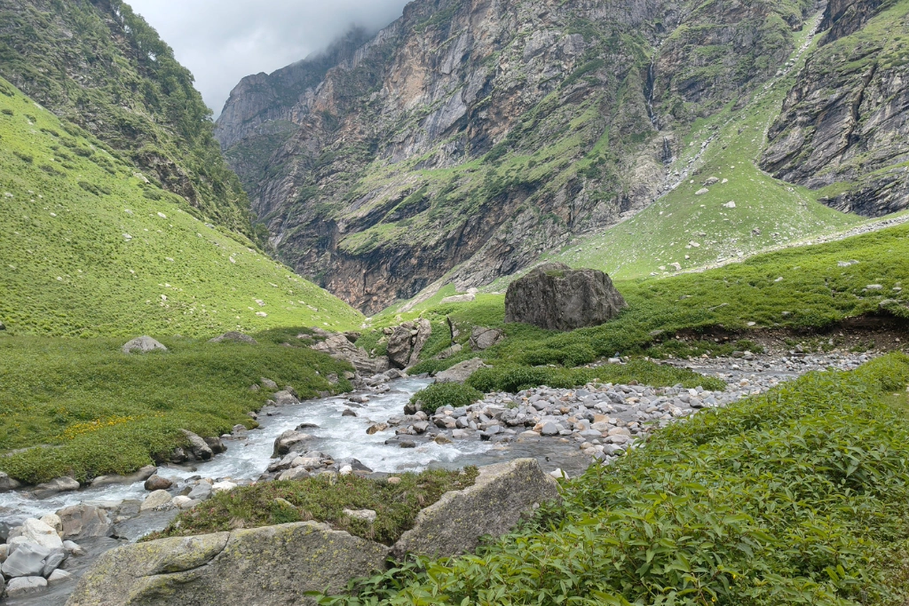 Green meadows beside a flowing river on the trek 