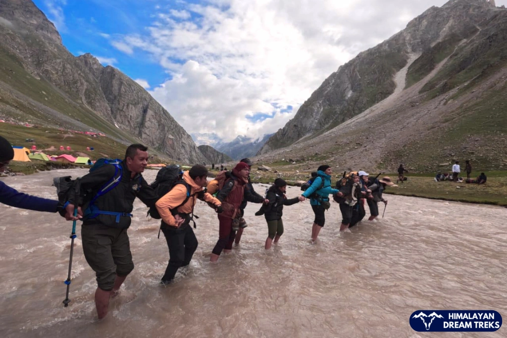 trekkers crossing the river