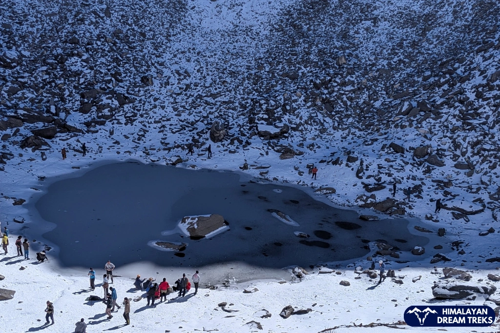 Frozen Roopkund Lake surrounded by snow-covered Himalayan mountains